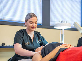 A UCOL learner performing a beauty treatment on a client at the salon.